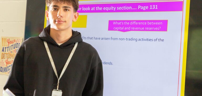 A Level Accounting student presenting to classroom in front of presentation