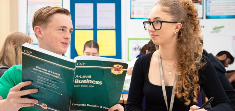 A Level Business students working with textbooks in classroom