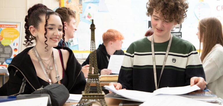 A Level French students working with French books and Eiffel tower prop in classroom
