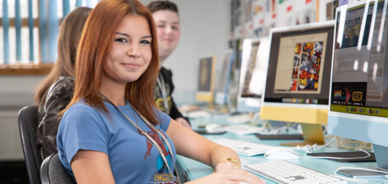 A Level Graphic Design student working on a Mac computer in the classroom
