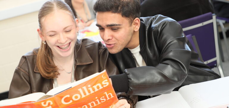 A Level Spanish students studying a Spanish dictionary in a classroom