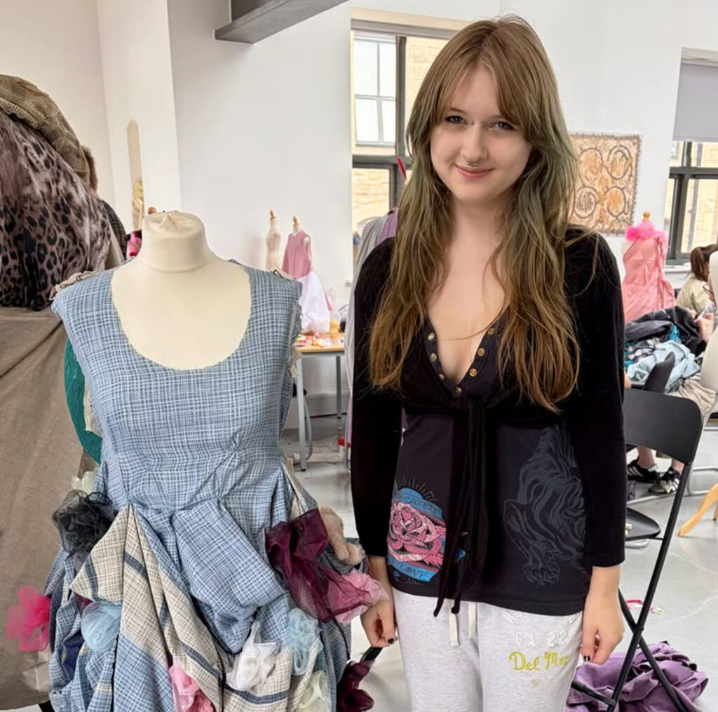 CR-7693 A Level Textiles Summer Project with student in front of textiles design